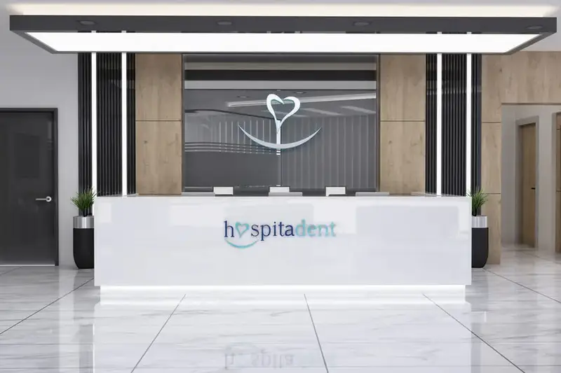 Bağcılar Hospitadent karşılama bankosu, beyaz tezgâh, ışıklı tavan çerçevesi ve ahşap kaplı yan duvarlar
