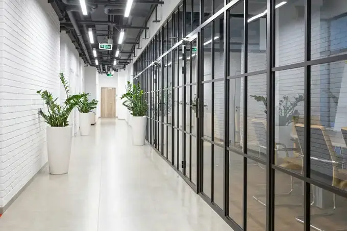 Temsilî görsel, ofis koridorunda siyah profilli cam bölme sistemi