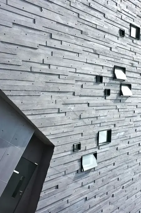 Temsilî görsel, ince taş şeritli cephe kaplaması ve küçük pencereler