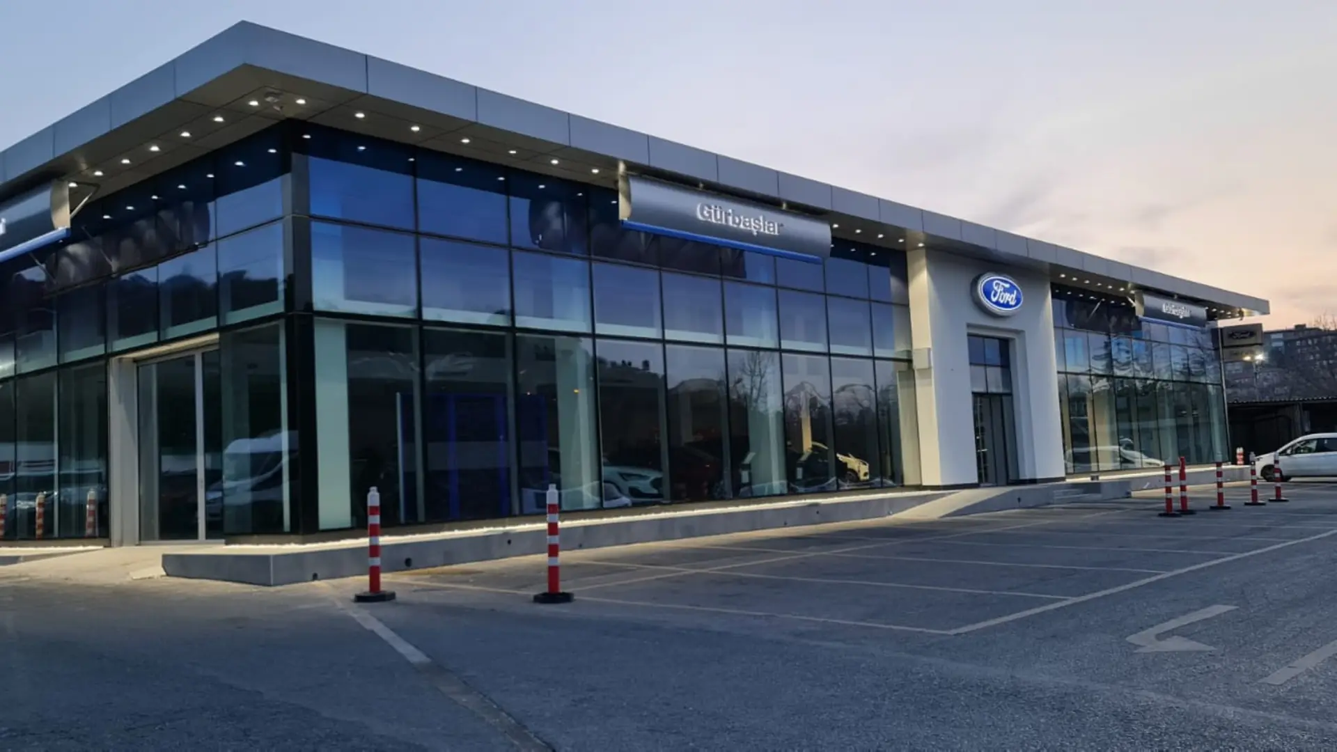 Gürbaşlar Showroom köşe cephesi gün batımında, giydirme cam cephe ve çıkma saçak