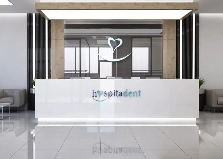 Hospitadent Çamlıca resepsiyon bankosu önden görünüm, arkadan aydınlatmalı ahşap pano ve cam bölmeler