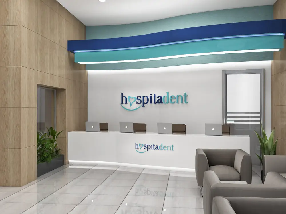 Hospitadent Şerifali resepsiyonu, logolu banko, dalgalı mavi tavan öğesi ve ahşap duvar kaplaması