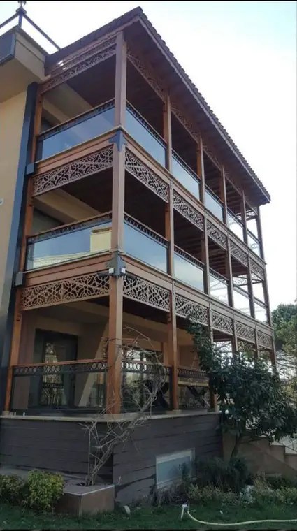 Villa Başdemir balkon cephesi, delikli metal korkuluk imalatı, cam balüstrat ve ahşap kolonlar